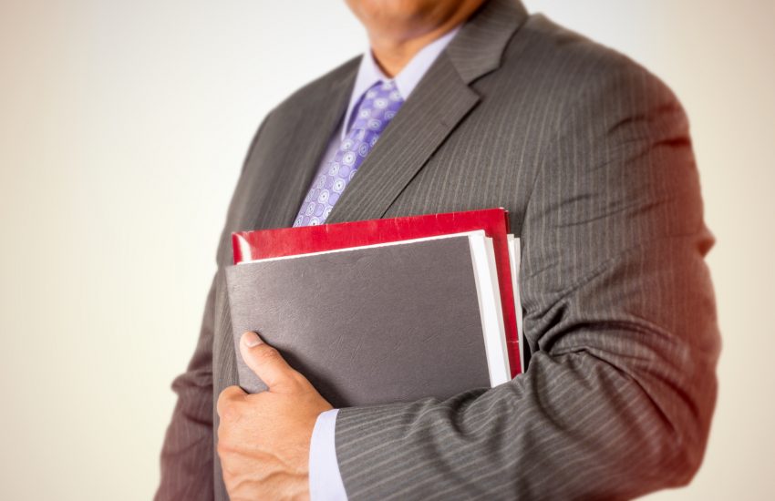 Businessman holding files against his suit